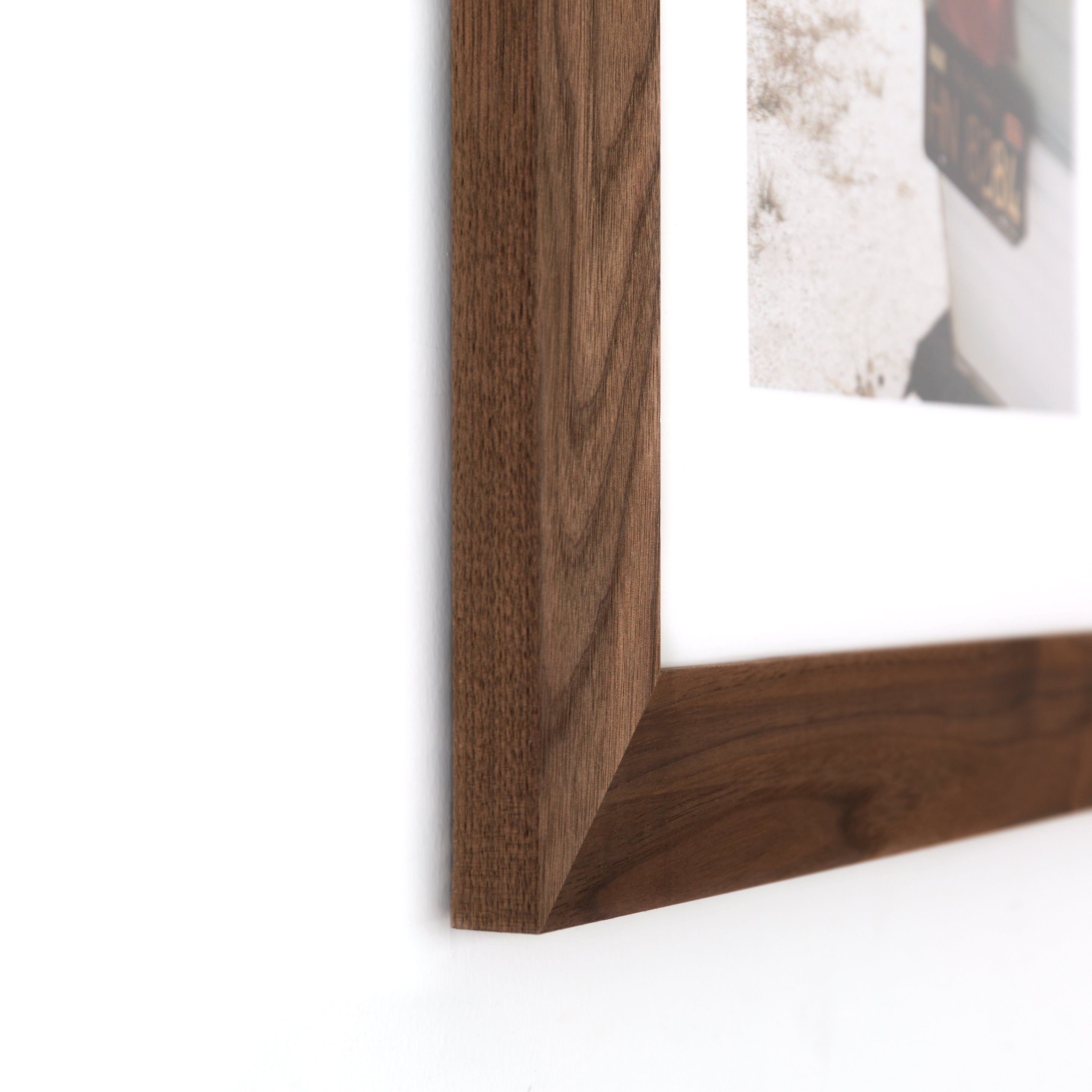 bottom left corner of photograph of the license plate on the back of a camper framed in Walnut Wide hardwood frame style with white mat