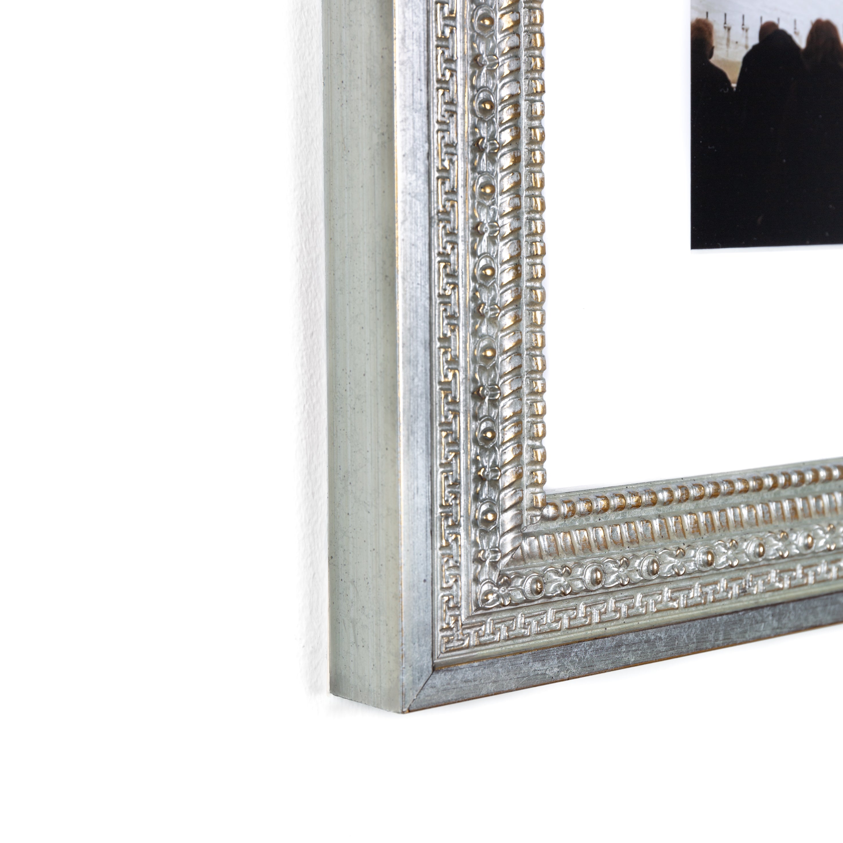 bottom left corner of a interior photo of a bar framed in ornate silver Brighton frame with a white mat