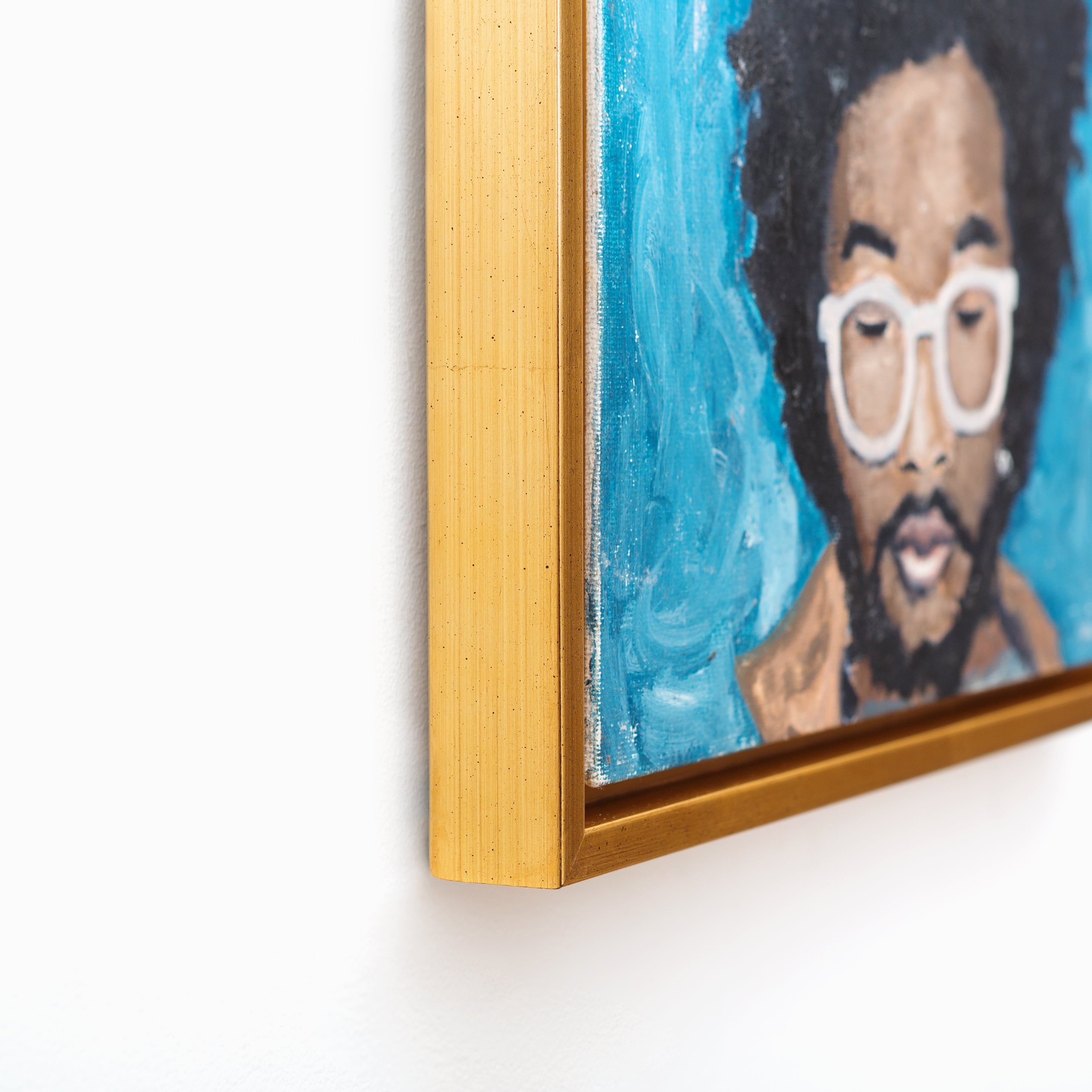 bottom left corner of painted portrait of a man wearing white glasses framed in Valencia gold floater style canvas frame