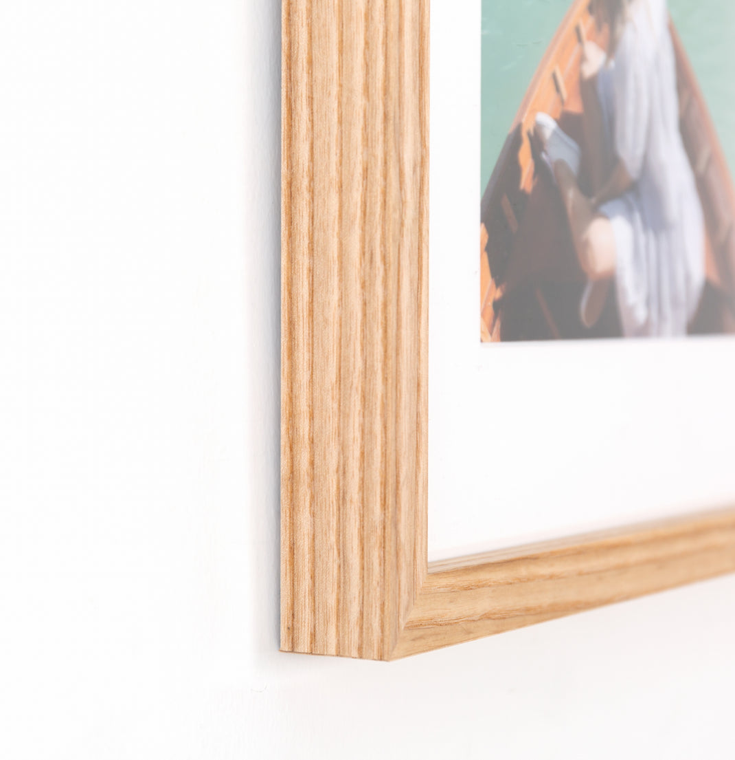 Bottom corner photo of Photo of a woman wearing a hat in a boat on a lake framed in Ash Gallery with a white mat