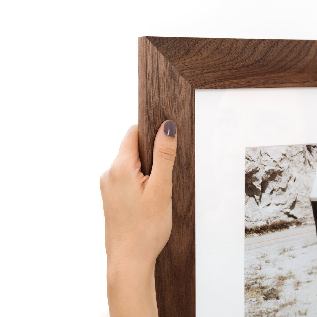 top left corner of photograph of the license plate on the back of a camper framed in Walnut Wide hardwood frame style with white mat