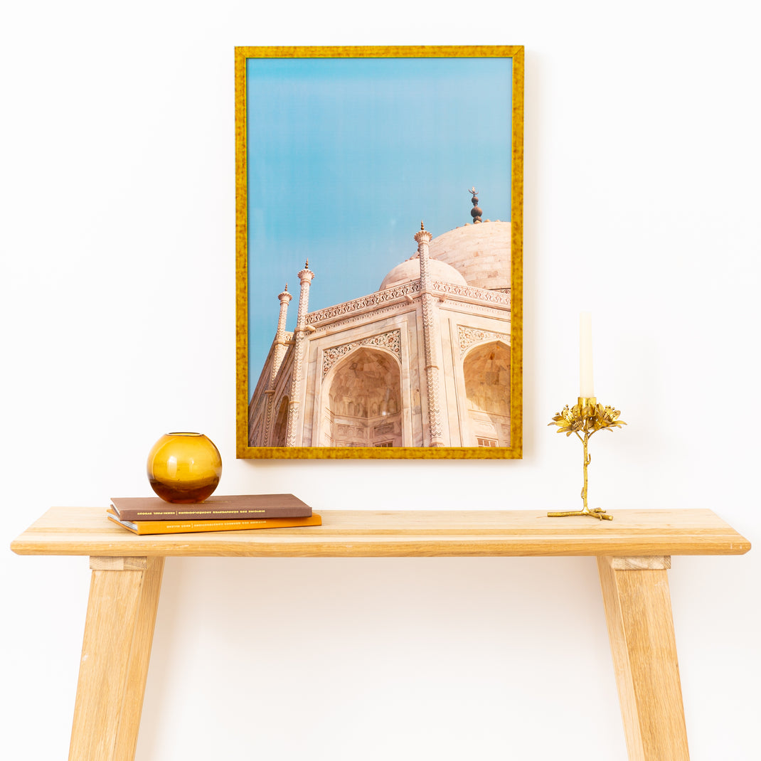 photo of the dome of a building framed in mustard yellow glazed Agra frame with no mat hanging on a white wall above a wood console table