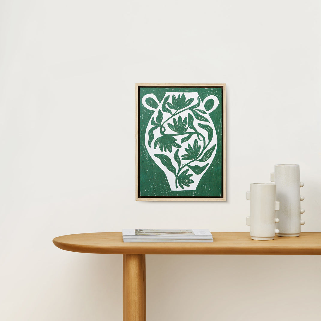 Colorful botanical canvas painting in a ash hardwood floater frame hanging on a white wall above wood console table