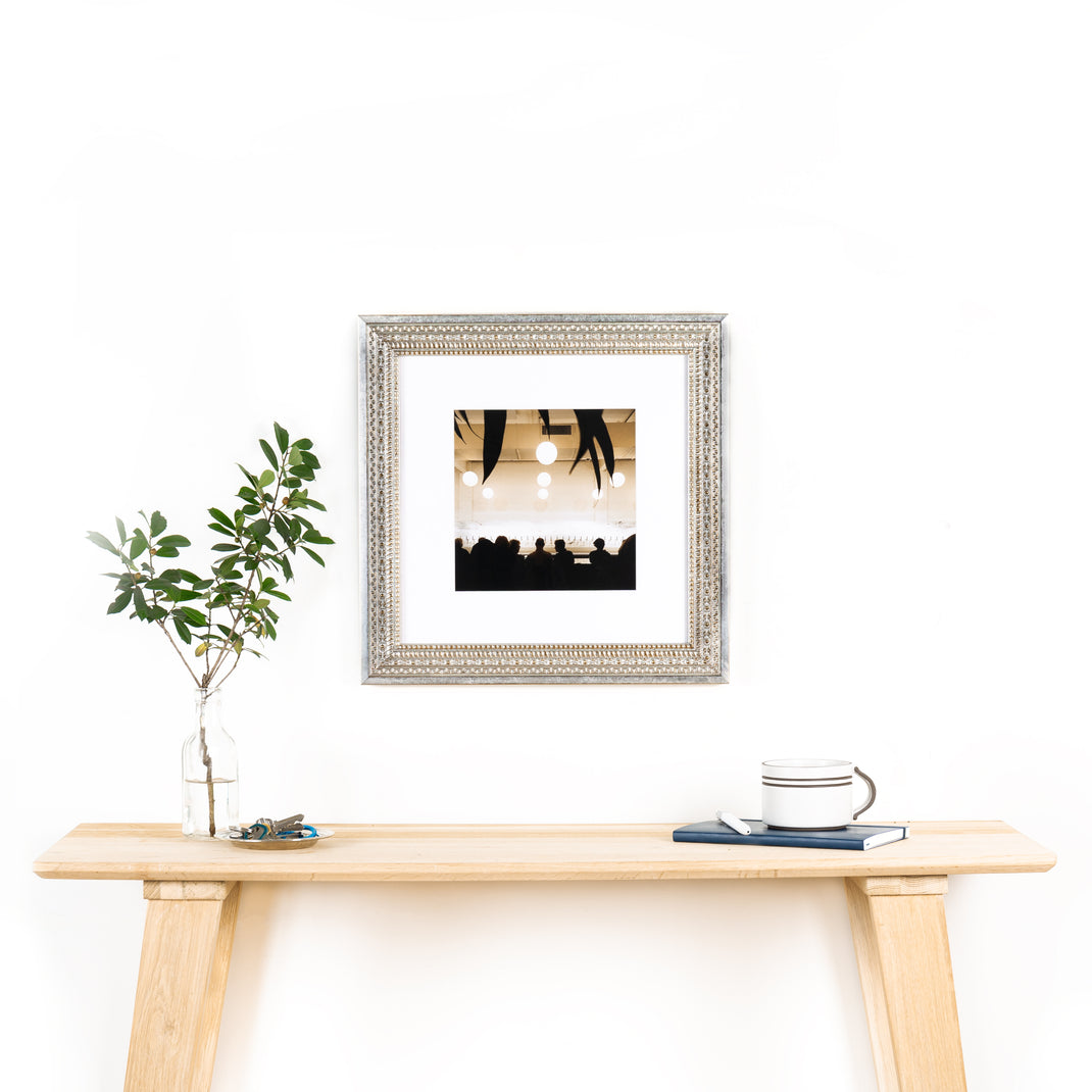 interior photo of a bar framed in ornate silver Brighton frame with a white mat