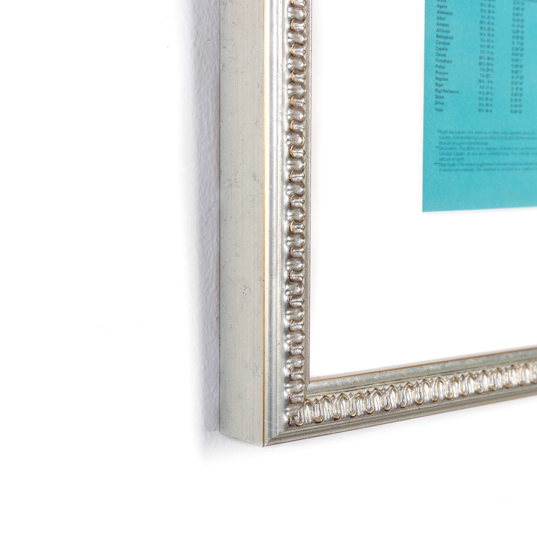 bottom left corner of star chart of the southern skies framed in Dover silver frame with wave detail