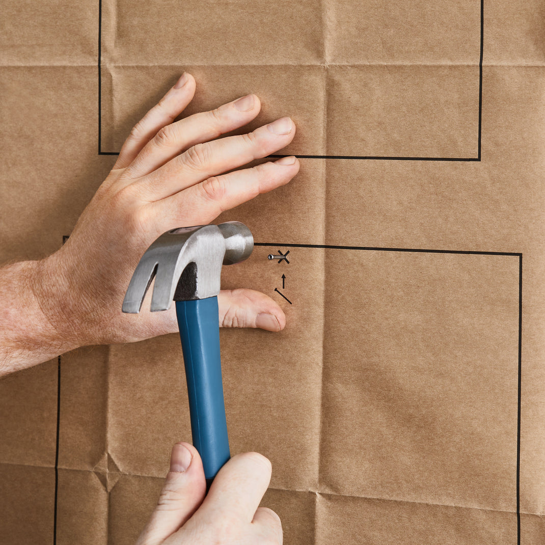 Hand with hammer hovering over nail
