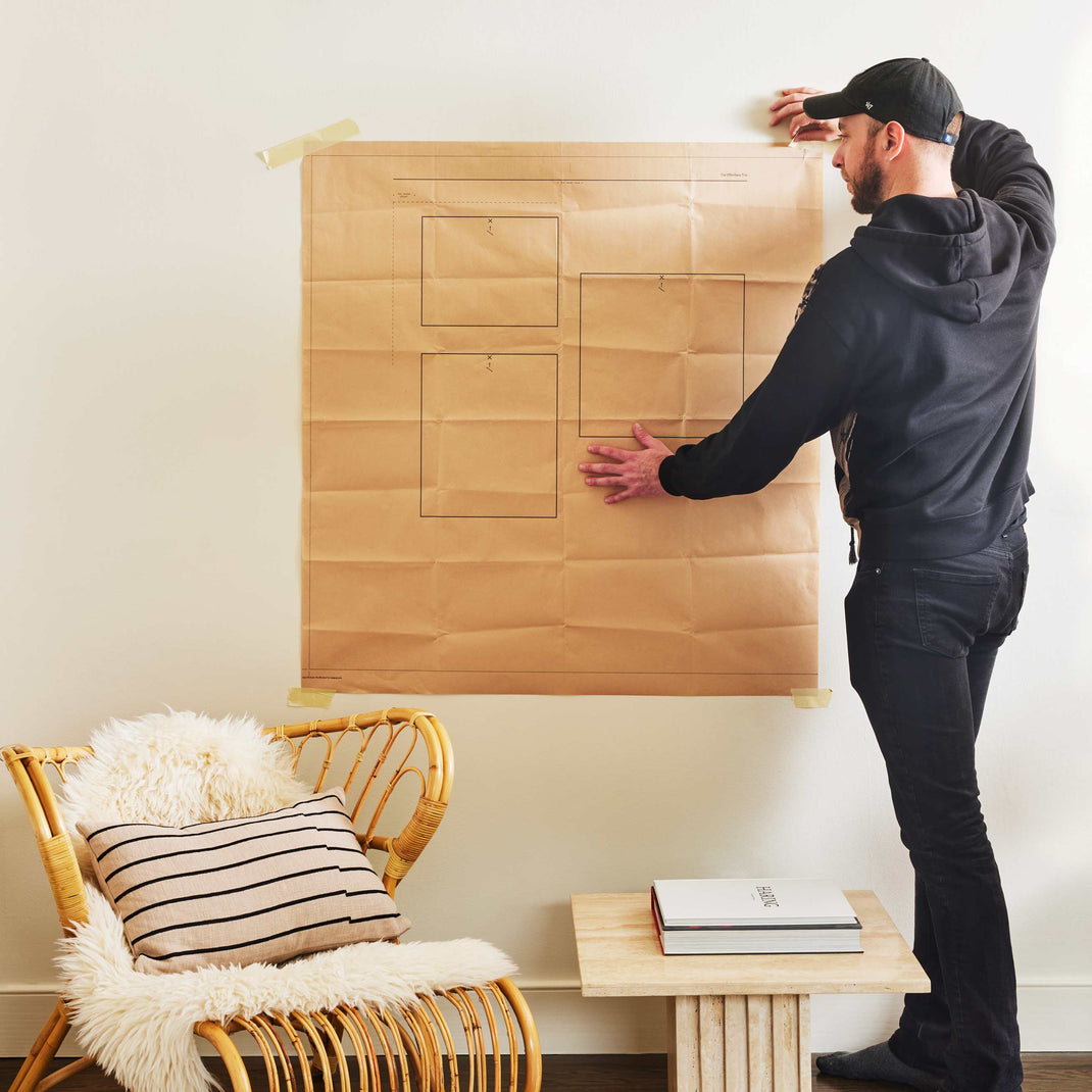 Man hanging The Organic Trio with our gallery wall hanging template