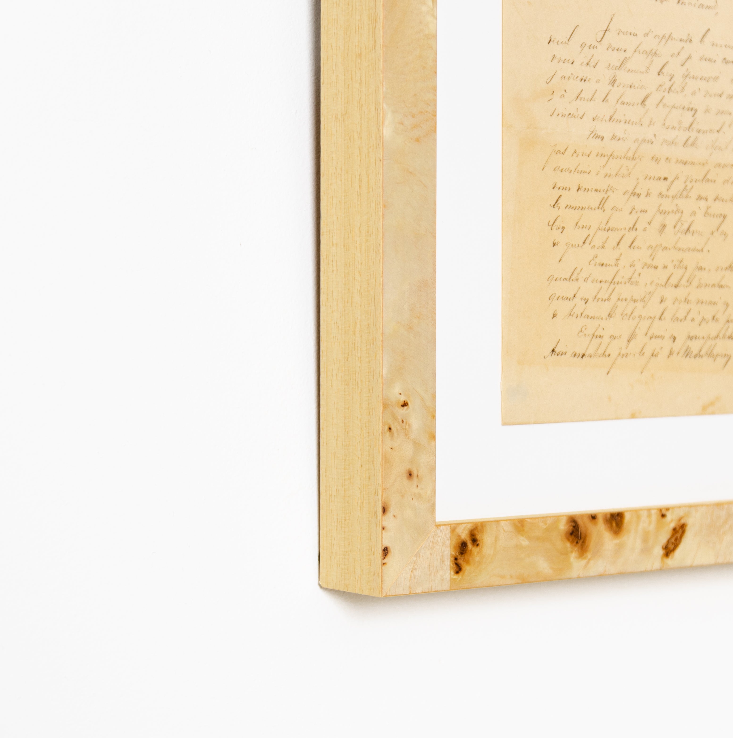 bottom left corner of vintage handwritten letter framed in gallery burl wood Giza frame with a white mat