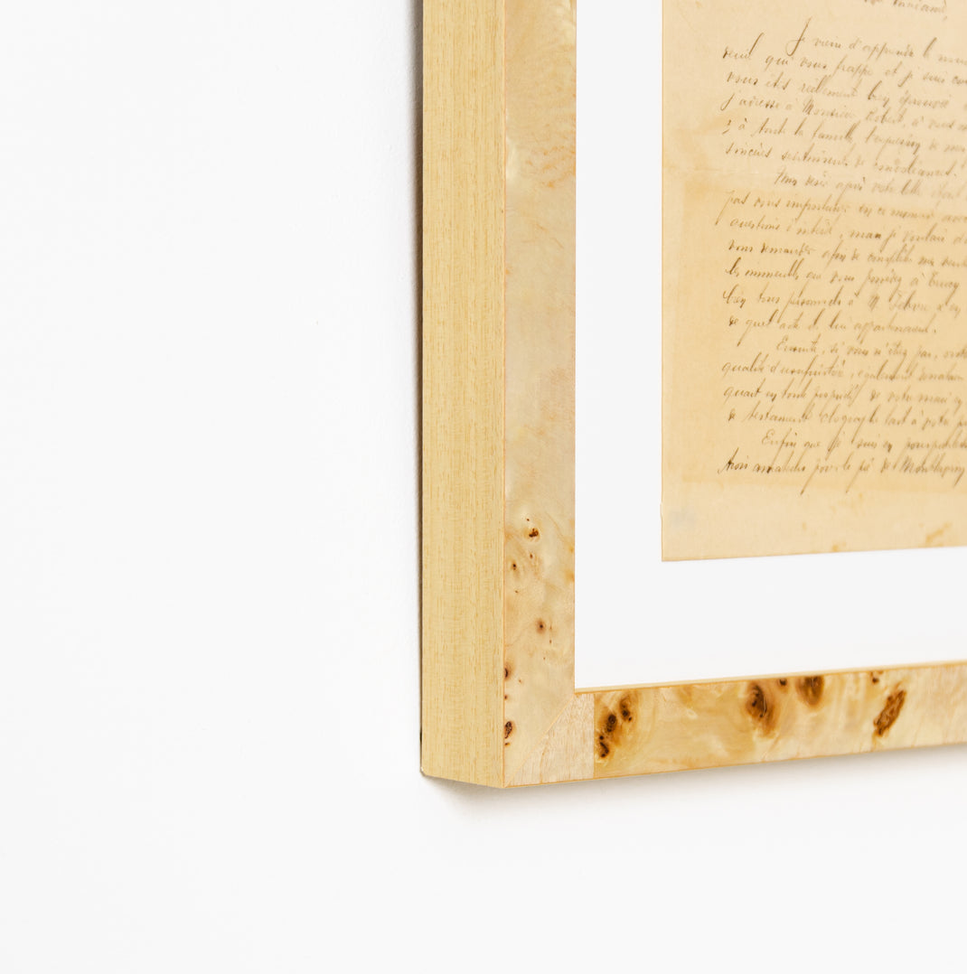 bottom left corner of vintage handwritten letter framed in gallery burl wood Giza frame with a white mat