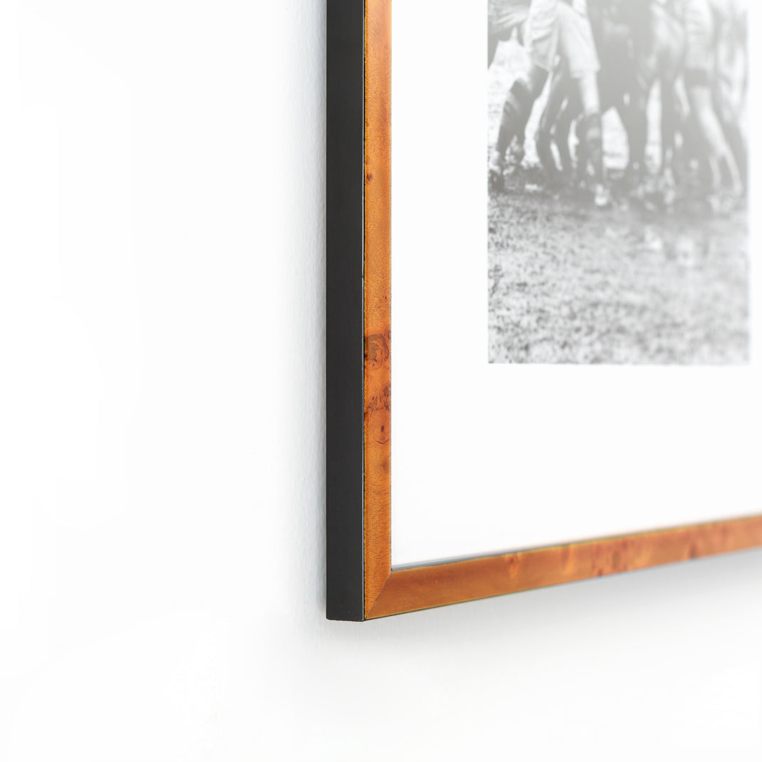 bottom left corner of vintage black and white rugby photo framed in thin honey burl wood Lawrence frame with a white mat