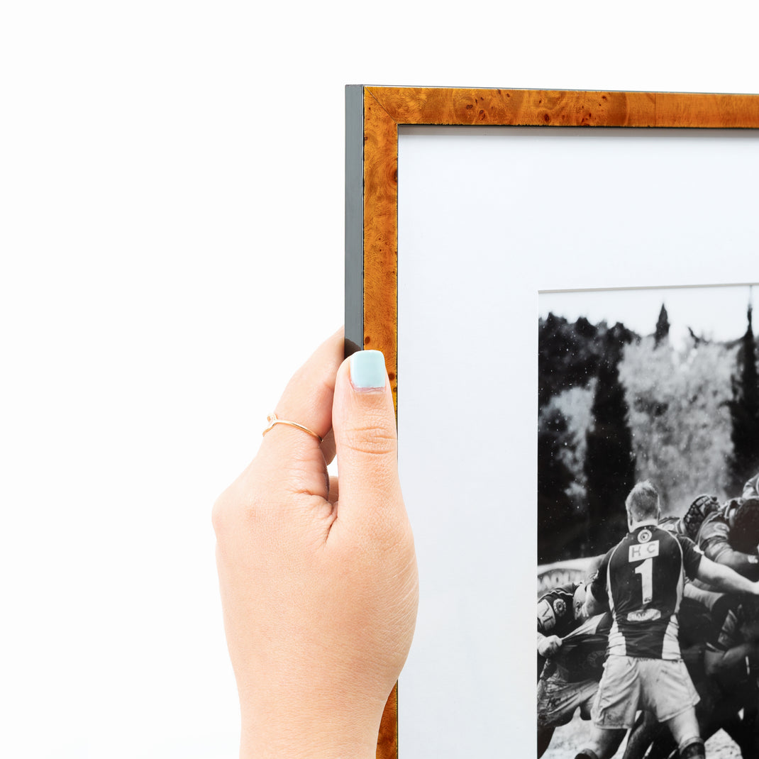 top left corner of vintage black and white rugby photo framed in thin honey burl wood Lawrence frame with a white mat