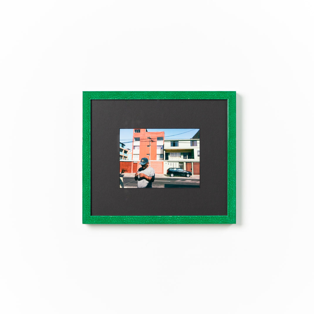 photo of a man on an urban street framed in emerald glazed green Lima frame with a black mat