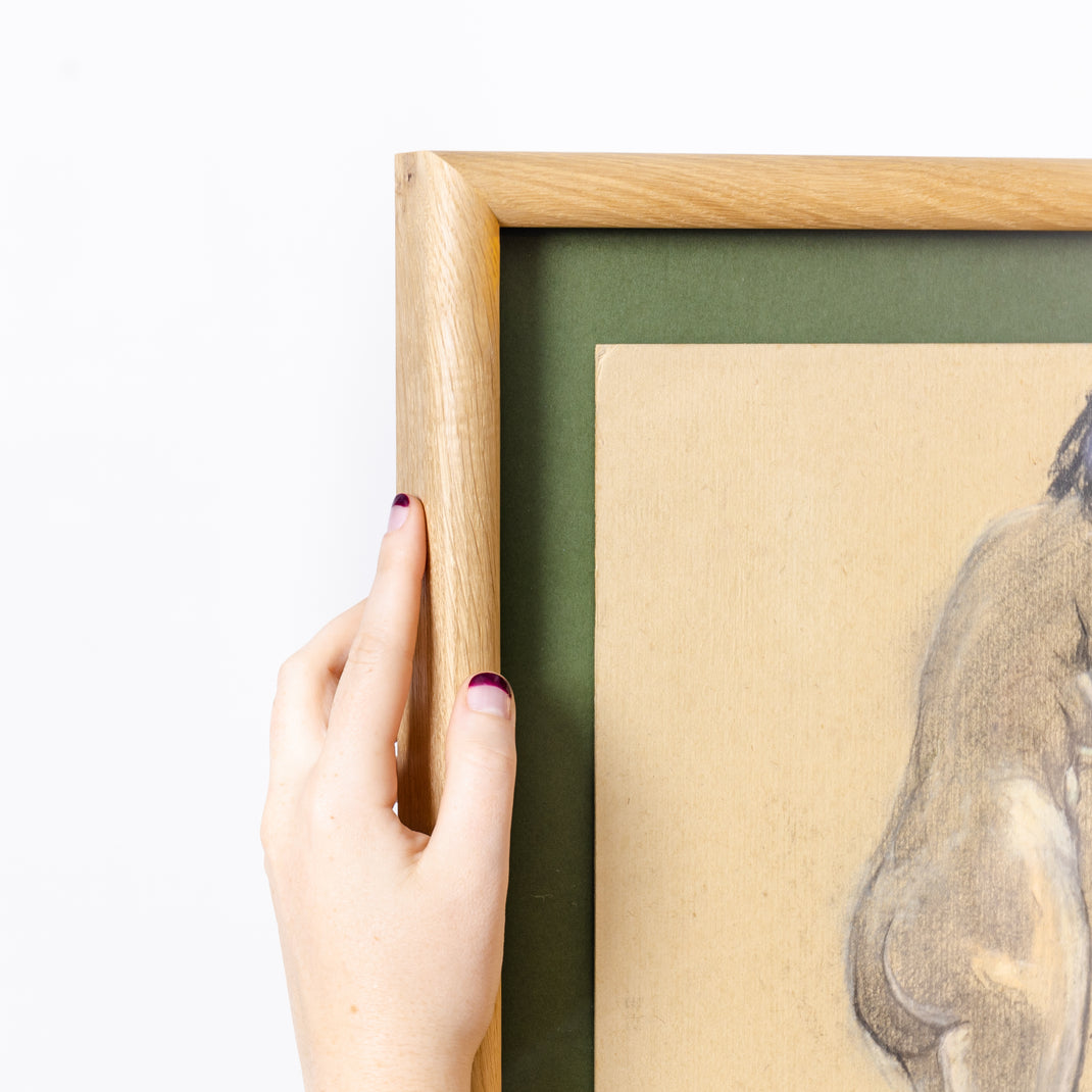 top left corner of charcoal figure drawing framed in rounded burl wood frame with a green mat