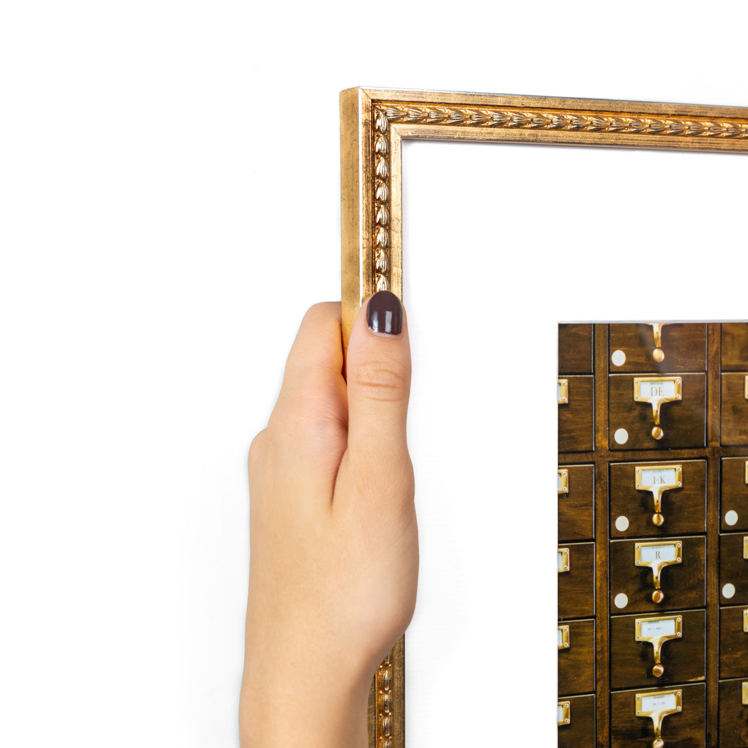 top left corner of photograph of library drawers framed in tuliped gold Montclare frame with a white mat