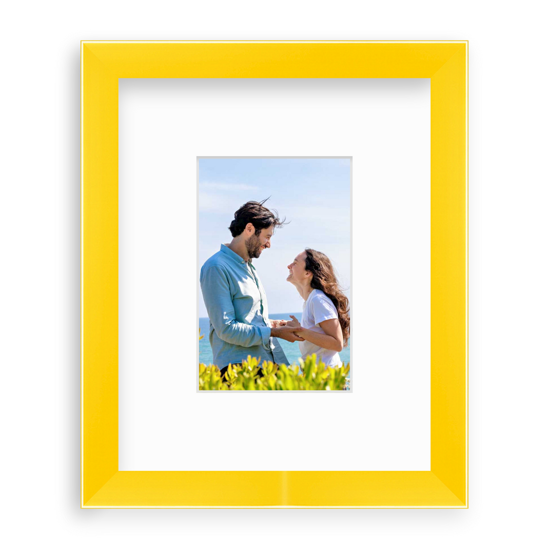 couple holding handing in yellow frame with white mat