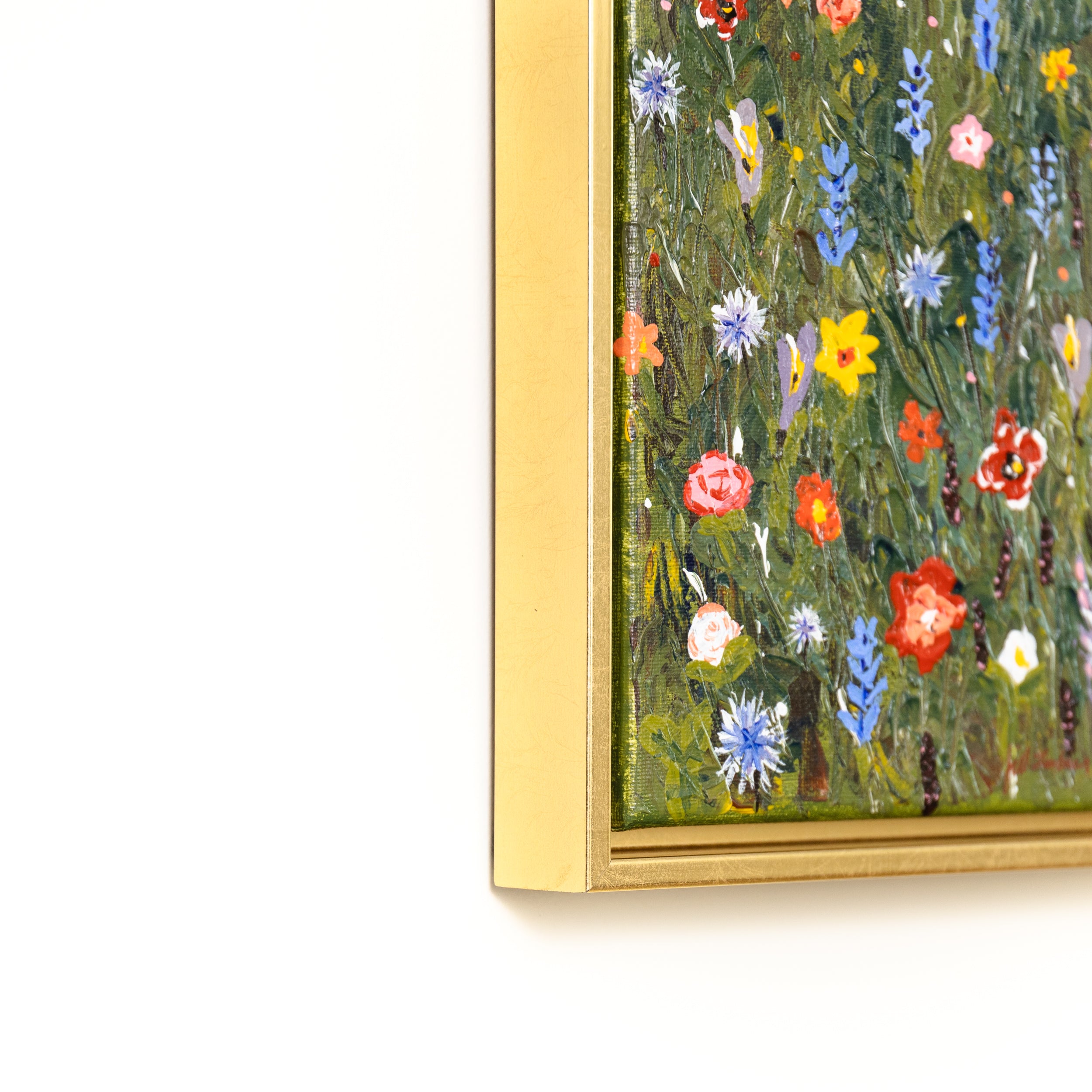 bottom left corner of painting of wildflowers on canvas framed in Quito gold canvas floater frame