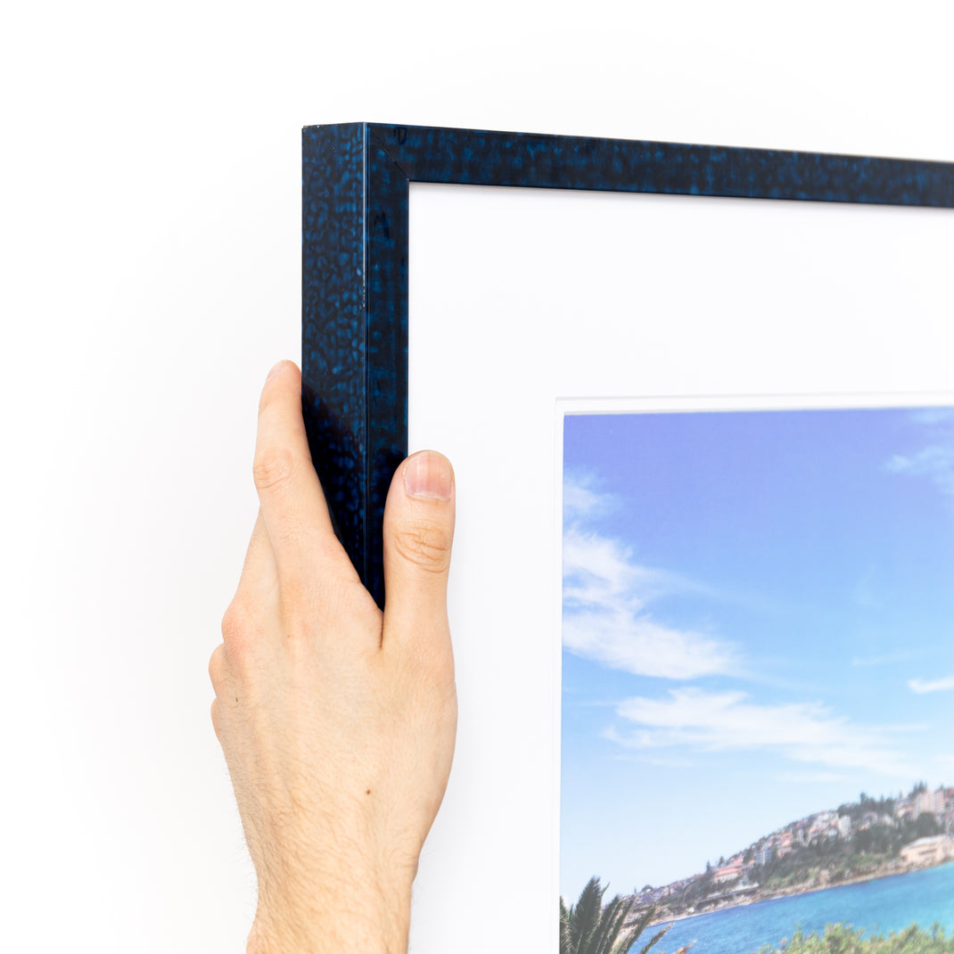 top left corner of a landscape photo framed in deep blue glazed Sydney frame with a white mat