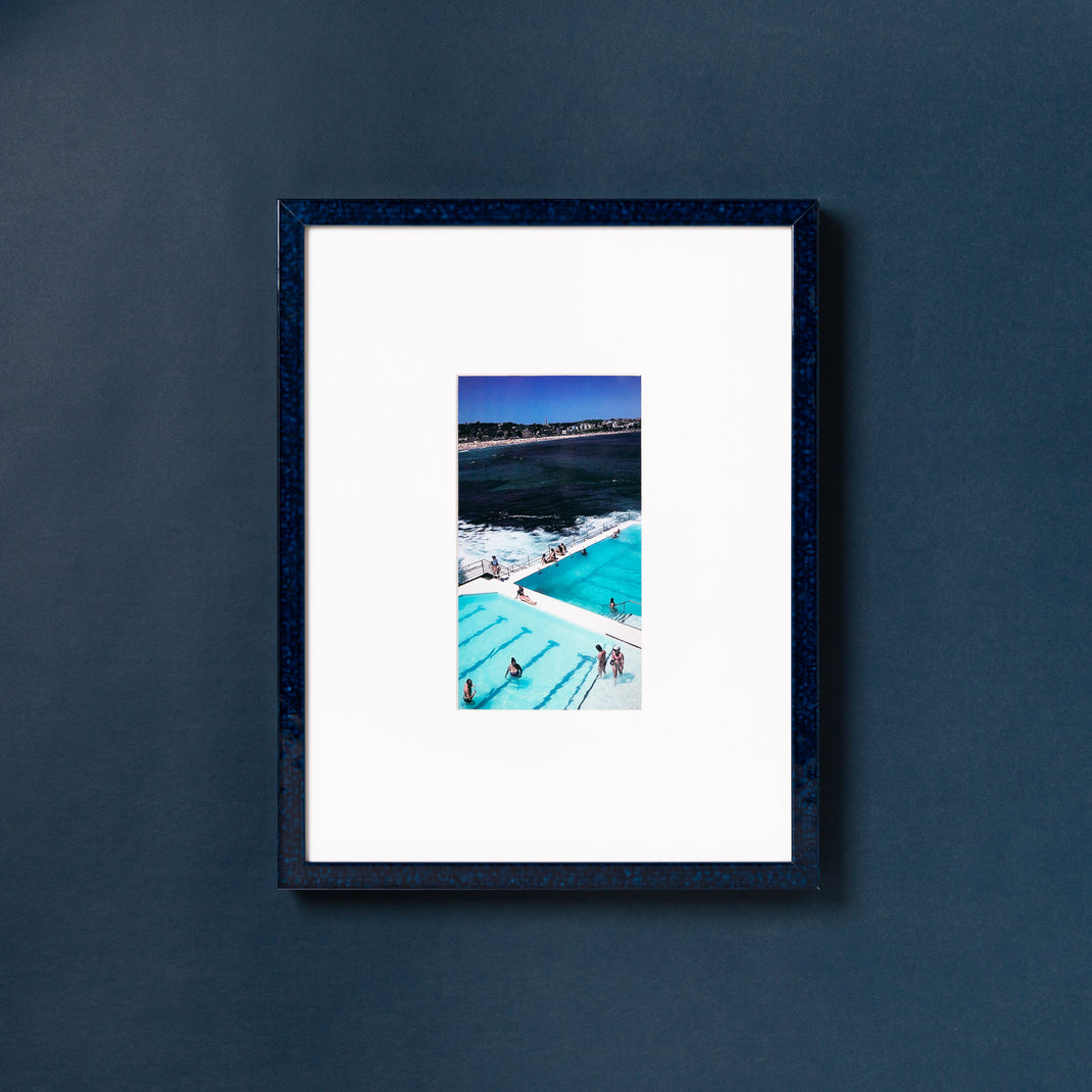photo of bright blue swimming pools framed in deep blue glazed Sydney frame with a white mat