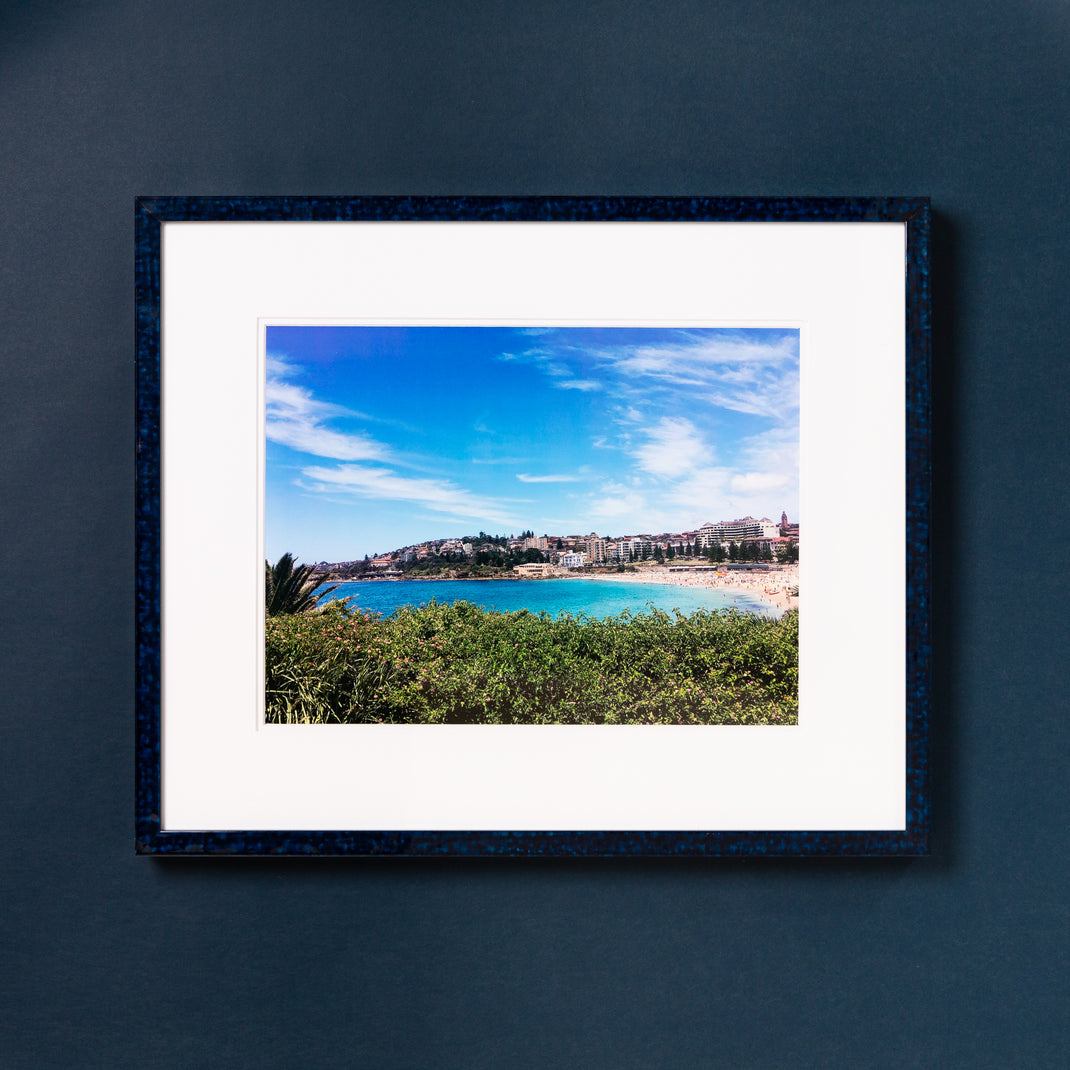 landscape photo of a beach framed in deep blue glazed Sydney frame with a white mat