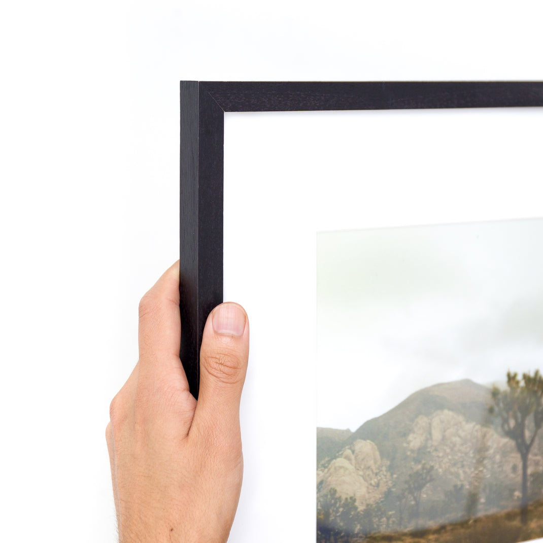 Top left corner of a Landscape photo of a desert mountain range framed in Black Walnut mini frame with white mat