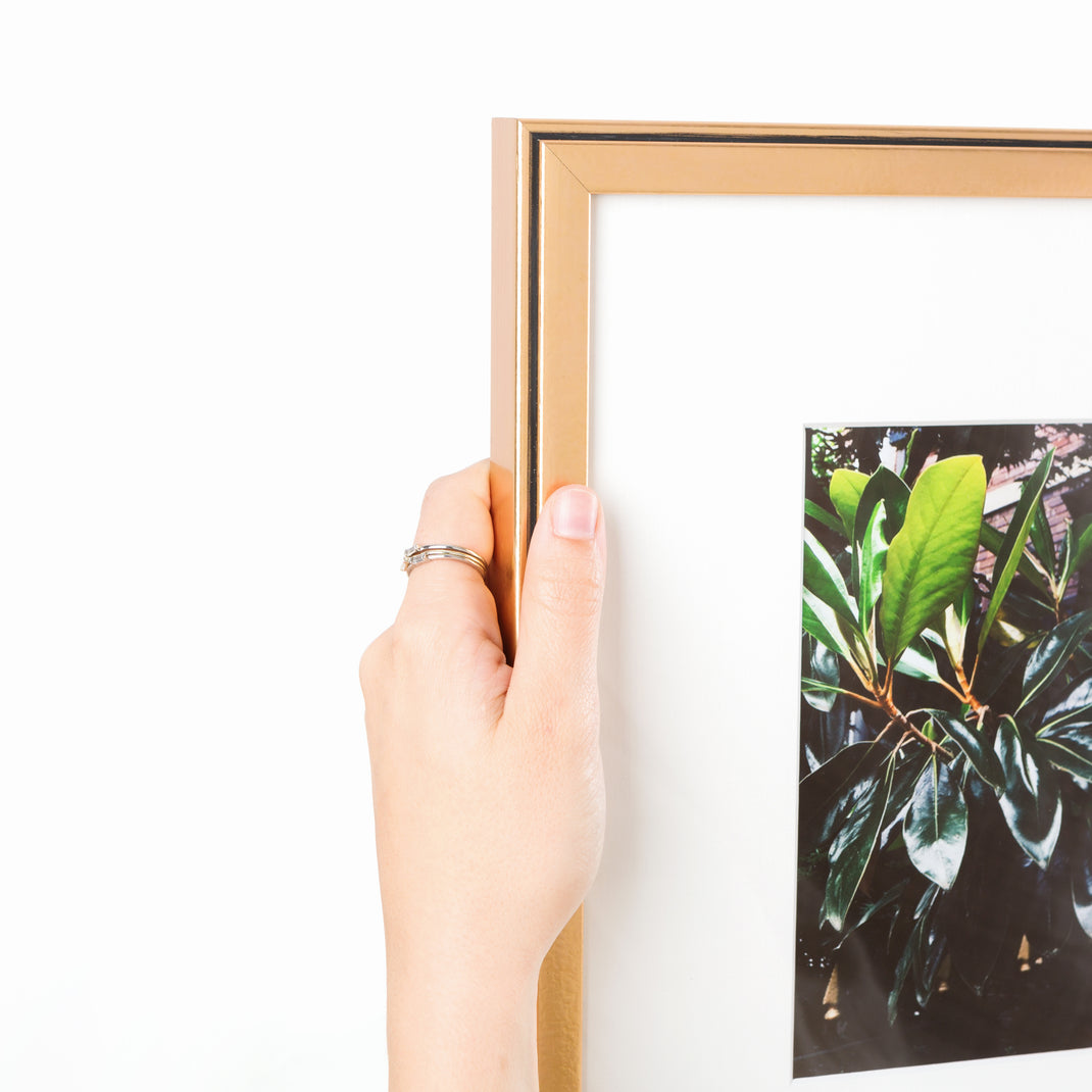 top left corner of photograph of a magnolia bloom framed in rose gold Rosemont frame with a white mat