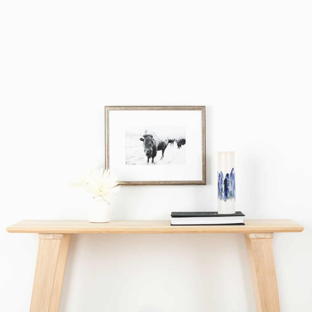 black and white photo of a buffalo framed in pewter silver Ventura frame with a white mat hanging on a white wall above wood console table