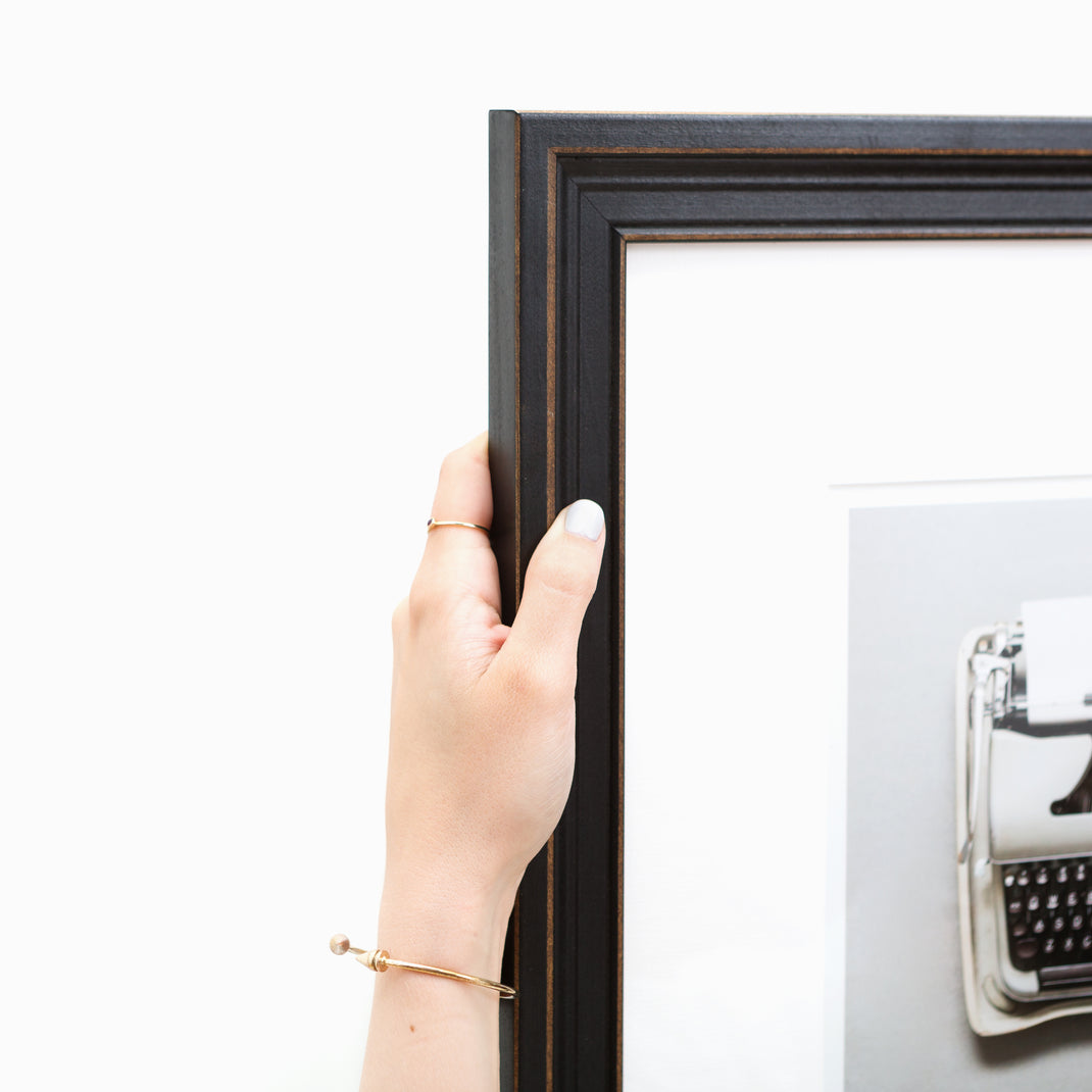 Top corner photo of Photo of a typewriter framed in Augusta wide distressed black frame with white mat