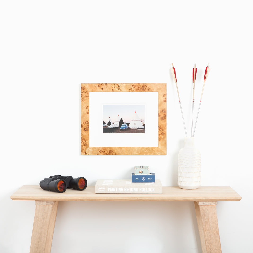 photograph of tents at a campsite framed in Cairo burl wood frame with a white mat hanging on a white wall above a wooden console table