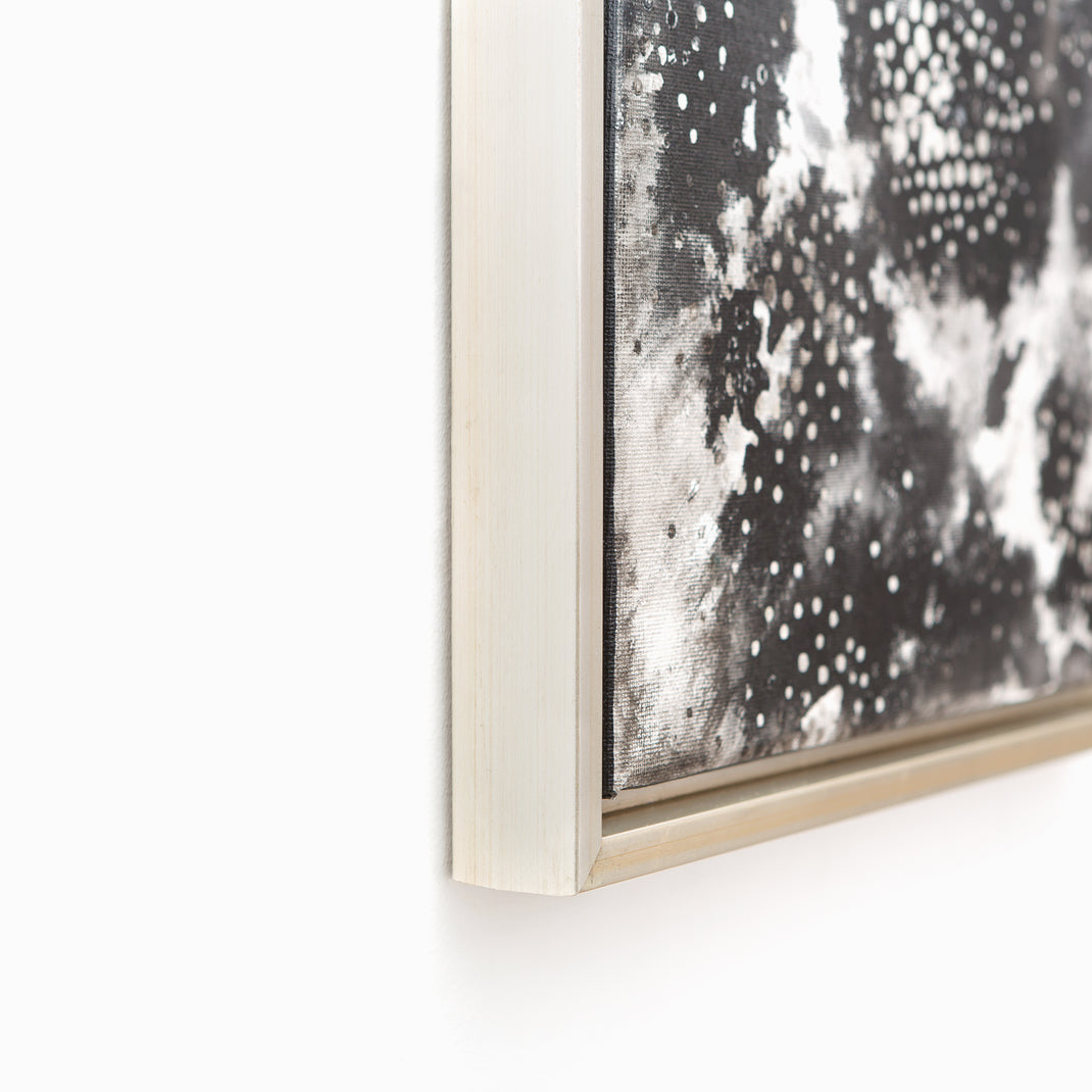 bottom left corner of a black and white canvas painting framed in Gatwick, a silver floater canvas frame