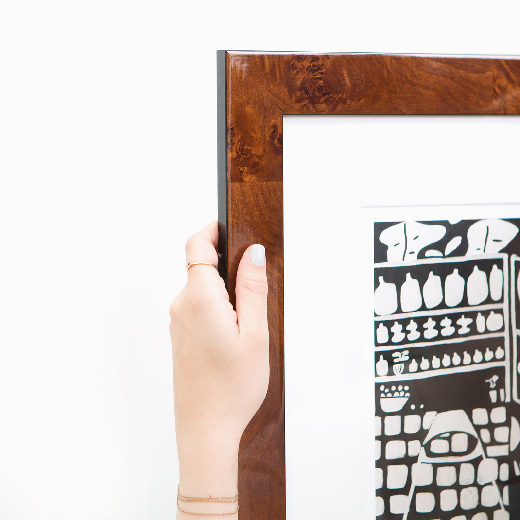 top left corner of black and white linocut print framed in Jambi tiger wood frame with white mat