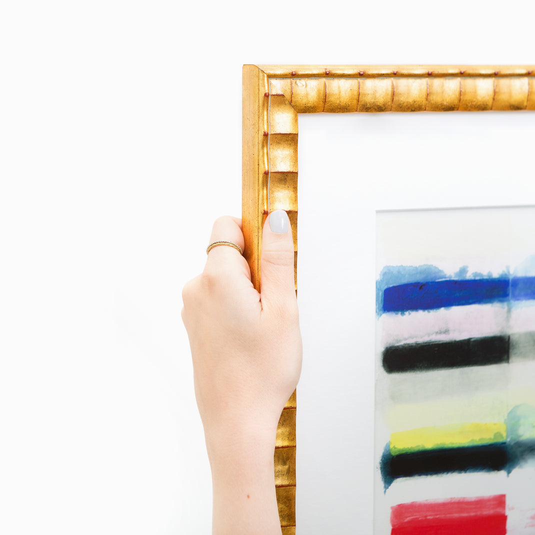 top left corner of abstract art framed in rippled gold Lafayette frame with a white mat