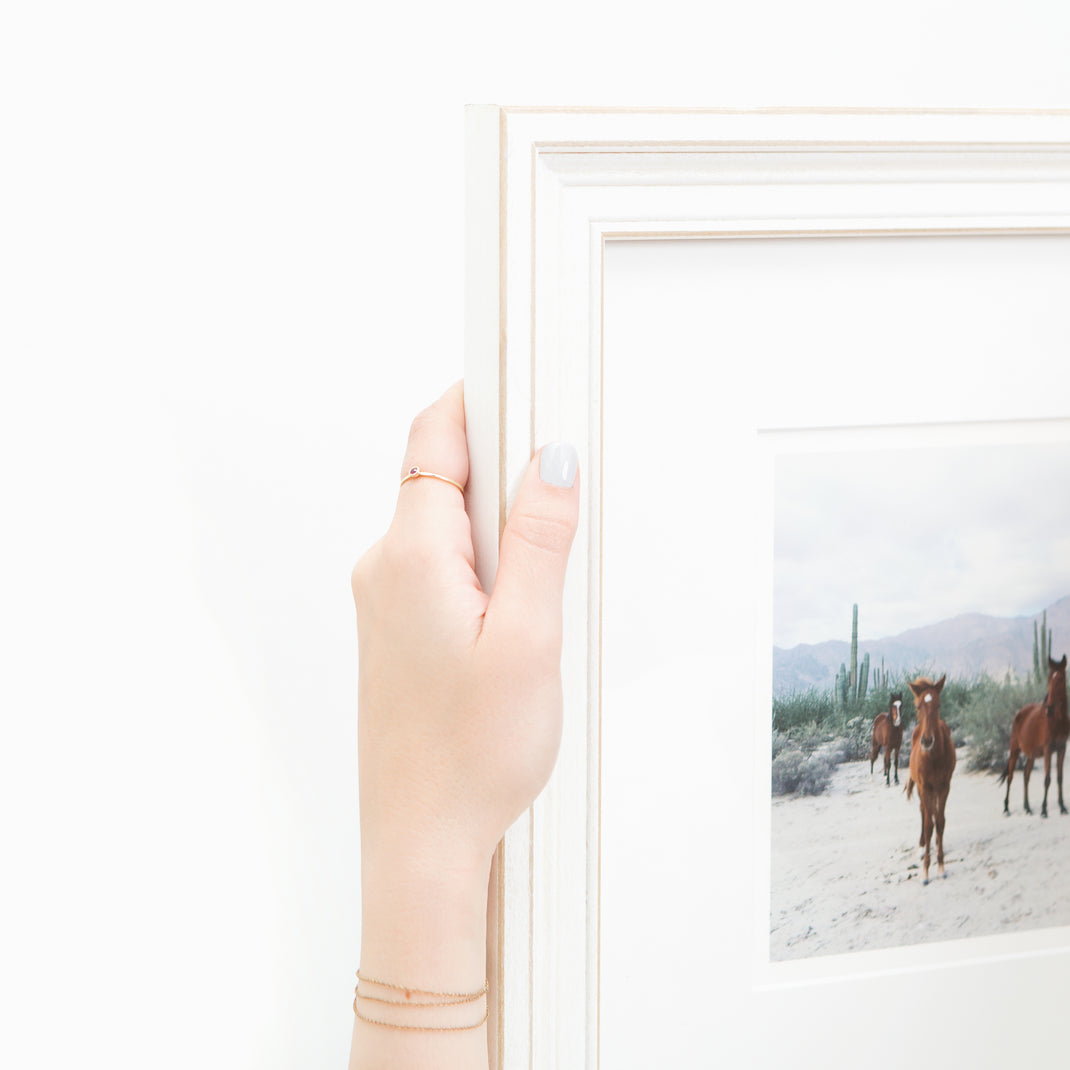 top left corner of photograph of horses in the desert framed in wide distressed Montauk frame with a white mat