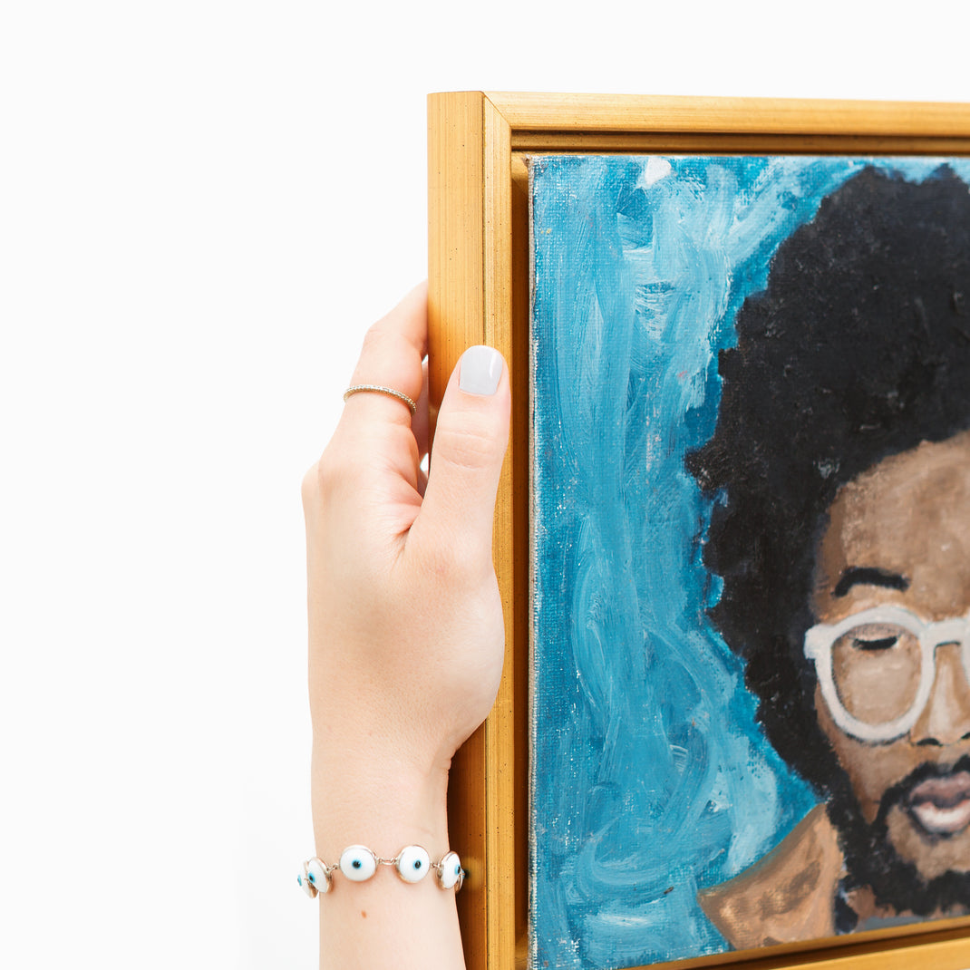 top left corner of painted portrait of a man wearing white glasses framed in Valencia gold floater style canvas frame